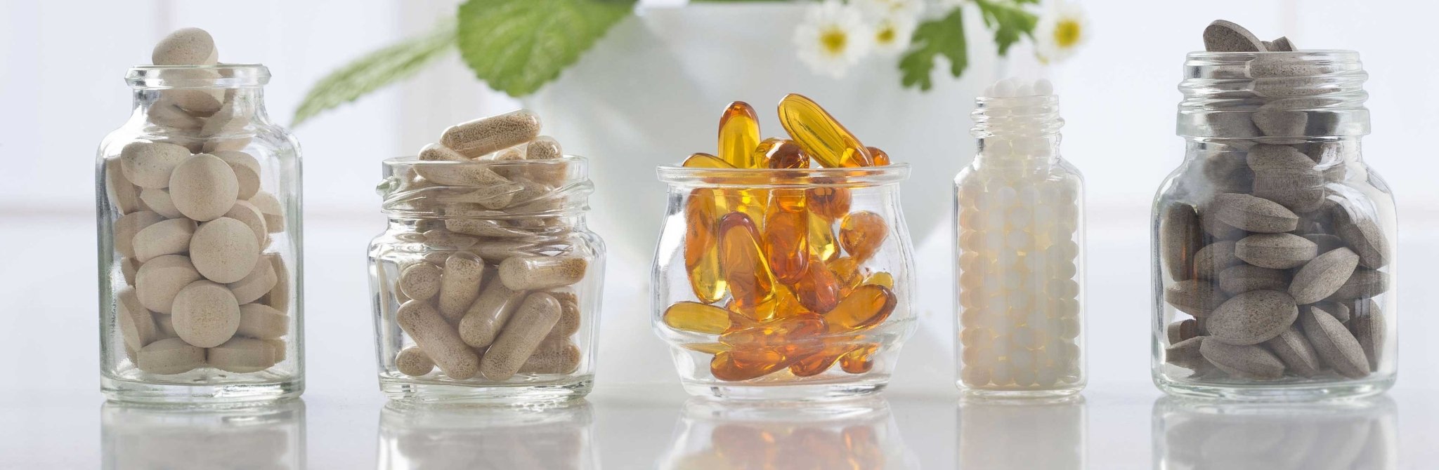 Vitamins Minerals in glass jars showcasing a variety of supplements for daily health essentials.